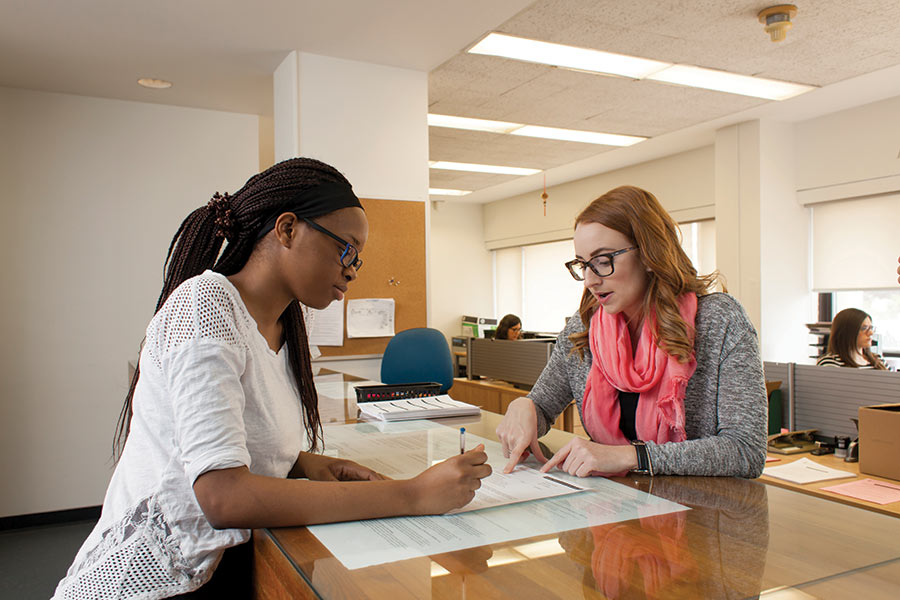 Academic advisor working with a student at the help desk within the Registrar's office.